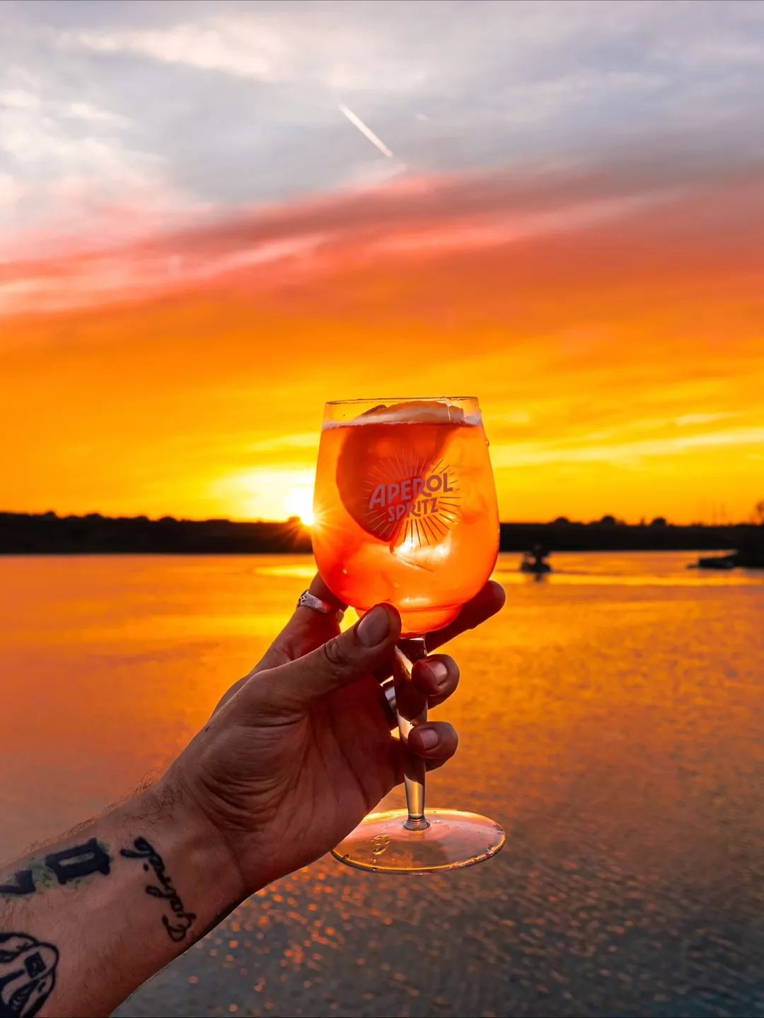 Aperol Spritz ridicat spre apus la un eveniment de vară Cofftails Events