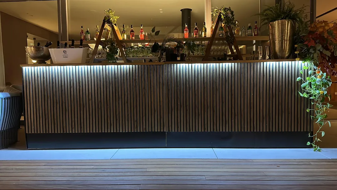 Bar mobil Cofftails Events cu riflaje din lemn și iluminare ambientală, montat la un eveniment privat în București