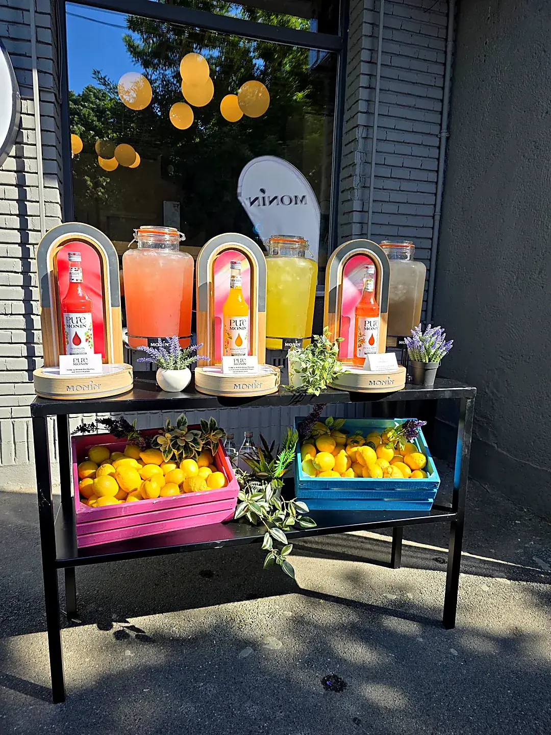 Bar de limonadă artizanală cu dispensere de limonadă și lădițe cu lămâi proaspete, amenajat în aer liber de Cofftails Events