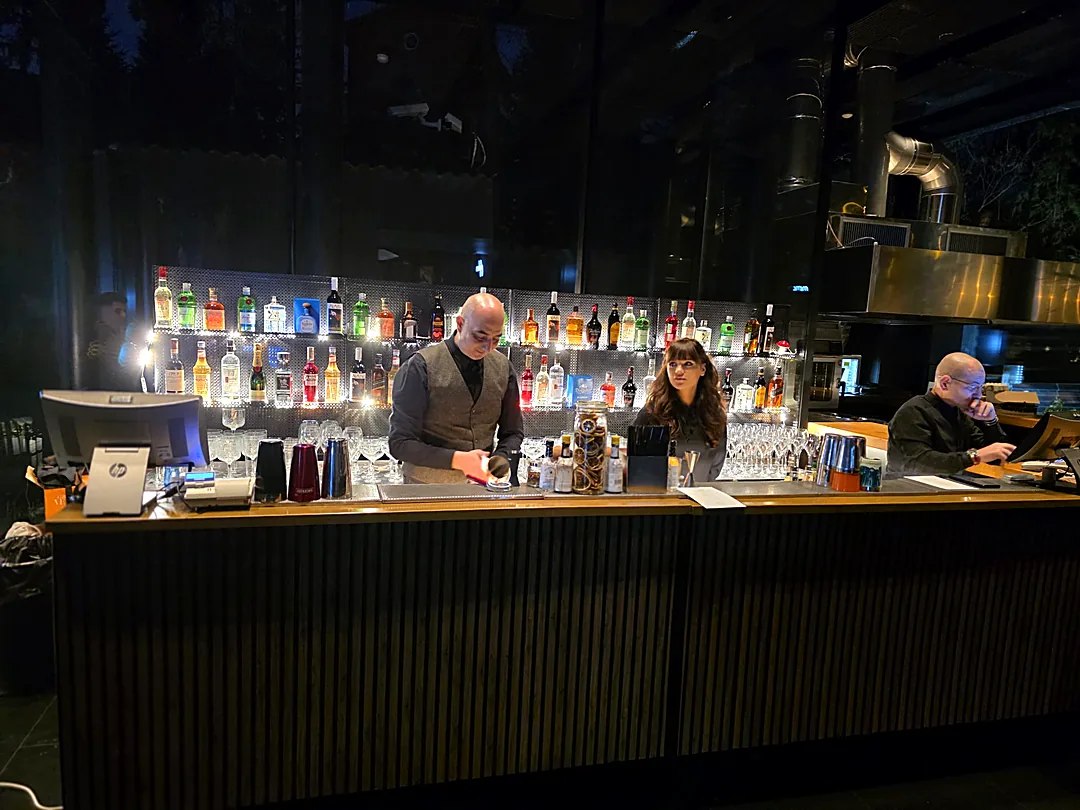 Barmanii Cofftails Events pregătind cocktailuri la barul mobil cu backbar iluminat, într-o seară de eveniment