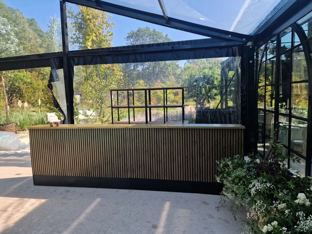 Bar mobil montat sub o structură de sticlă, la un eveniment privat
