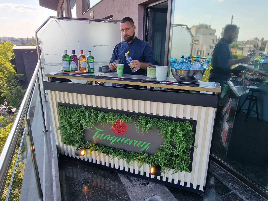 Barman Cofftail's Events la un bar mobil branduit Tanqueray, montat pe o terasă de rooftop
