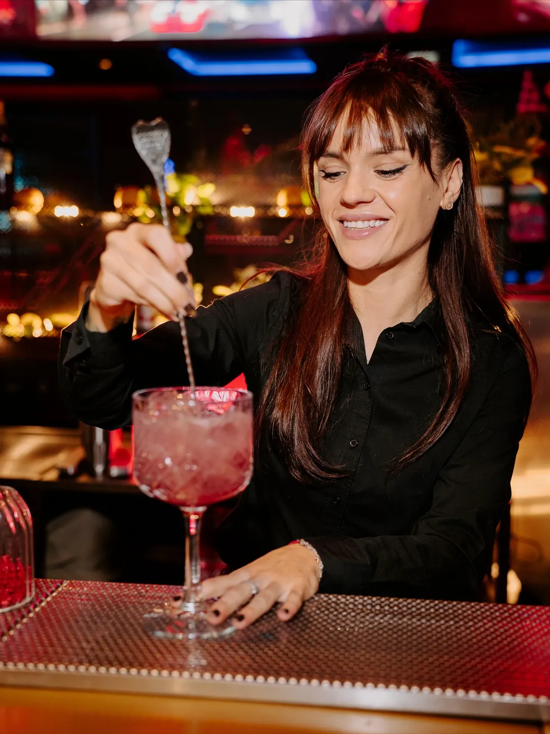 Barmaniță Cofftails Events garnisind un cocktail cu atenție la detalii, la barul mobil