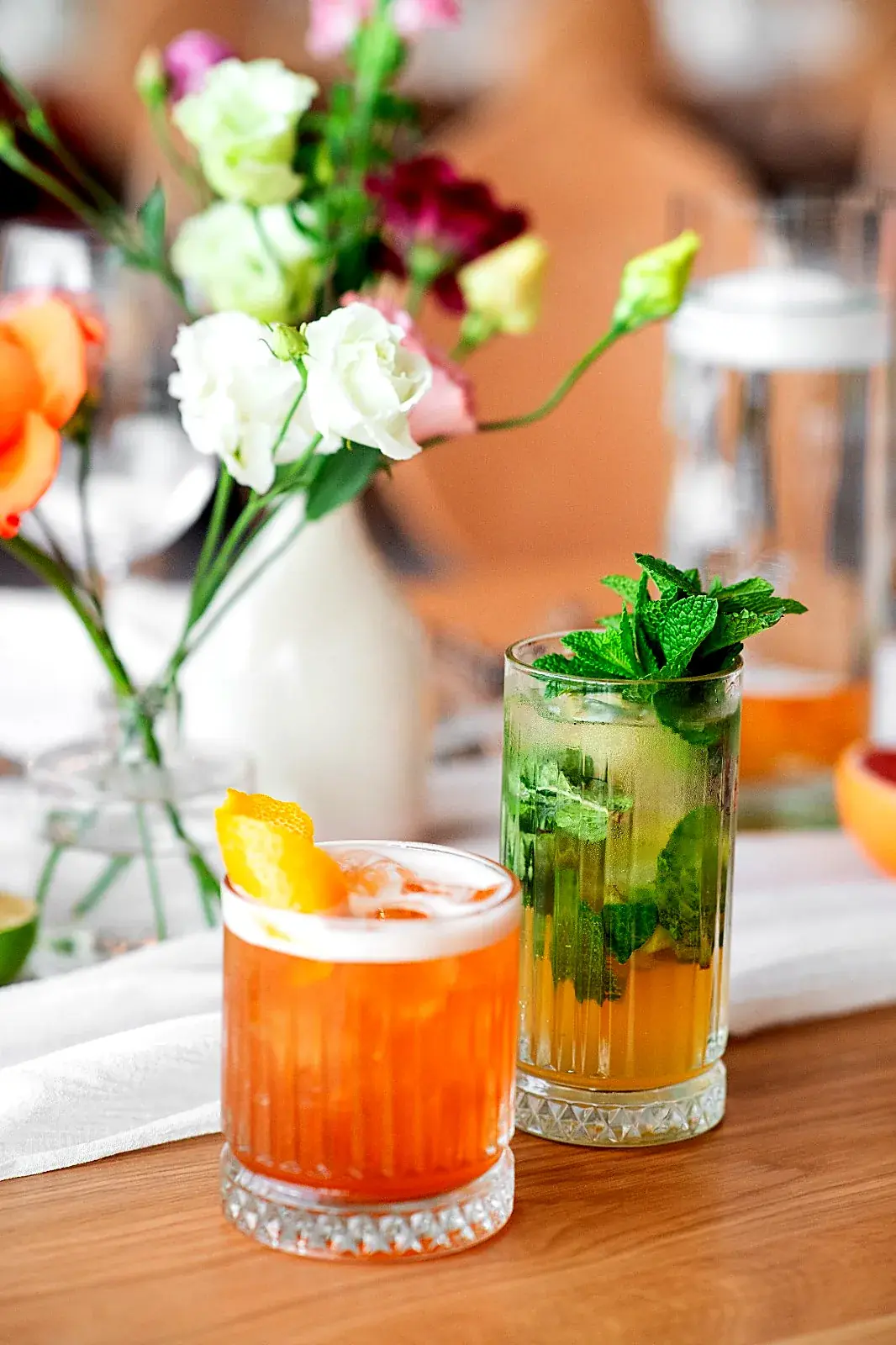 Cocktailuri așezate pe o masă cu aranjament floral, la o nuntă