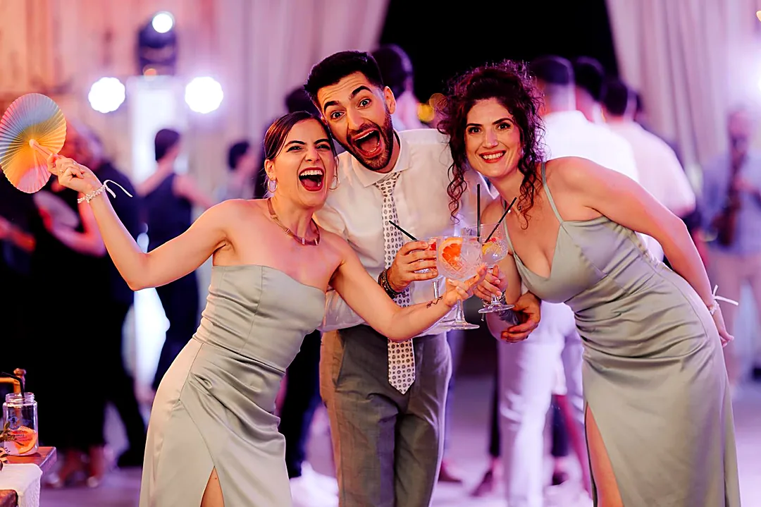 Invitați veseli ciocnind cocktailuri pe ringul de dans la o nuntă